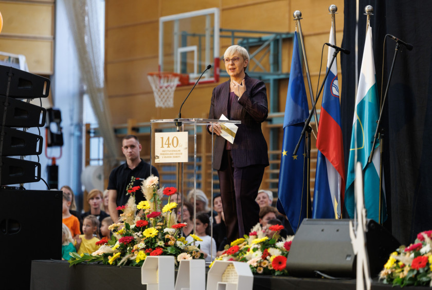 Predsednica na odru nagovarja udeležence prireditve.